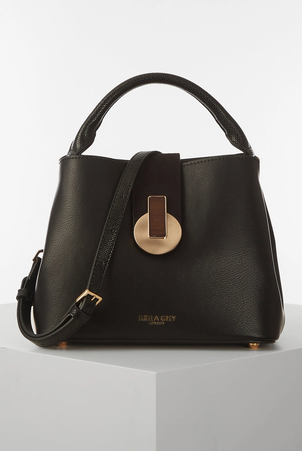 Black structured handbag with top handle and gold-tone front clasp, side strap