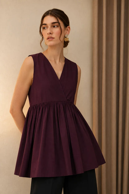 Maroon sleeveless V-neck peplum top with gathered waist