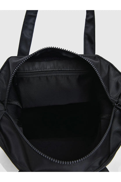 Black tote bag interior with wide opening and stitched trim