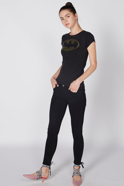 Black graphic T-shirt with gold bat emblem, paired with black pants