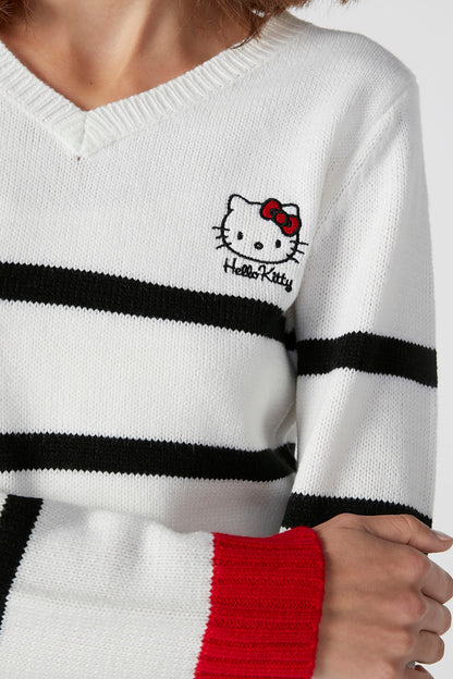 Close-up of white knit sweater: black stripe band and Hello Kitty graphic