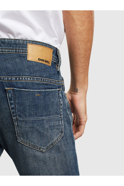 Blue denim jeans back pocket with tan label reading DIESEL