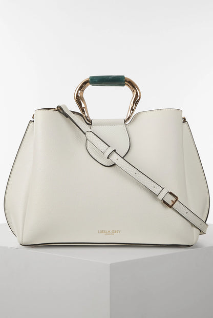 White handbag with green top handle and gold-tone rings