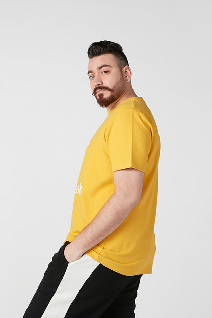 Yellow short-sleeve T-shirt with white star graphic and 'new feels' print, side view