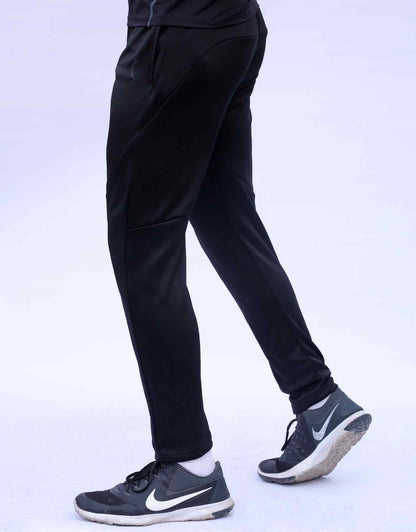 Black jogger pants, angled side view with tapered ankle and seam shaping
