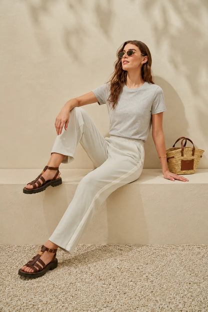Grey t-shirt and white drawstring pants, seated pose with sandals