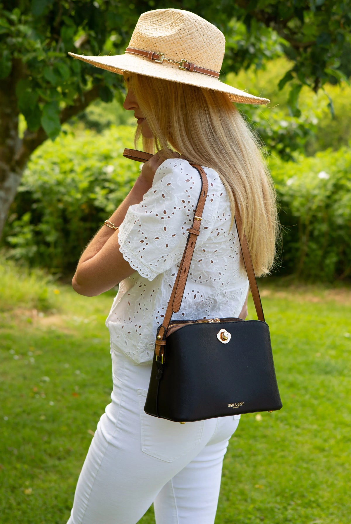 Black mini shoulder bag with gold twist-lock clasp and thin leather strap