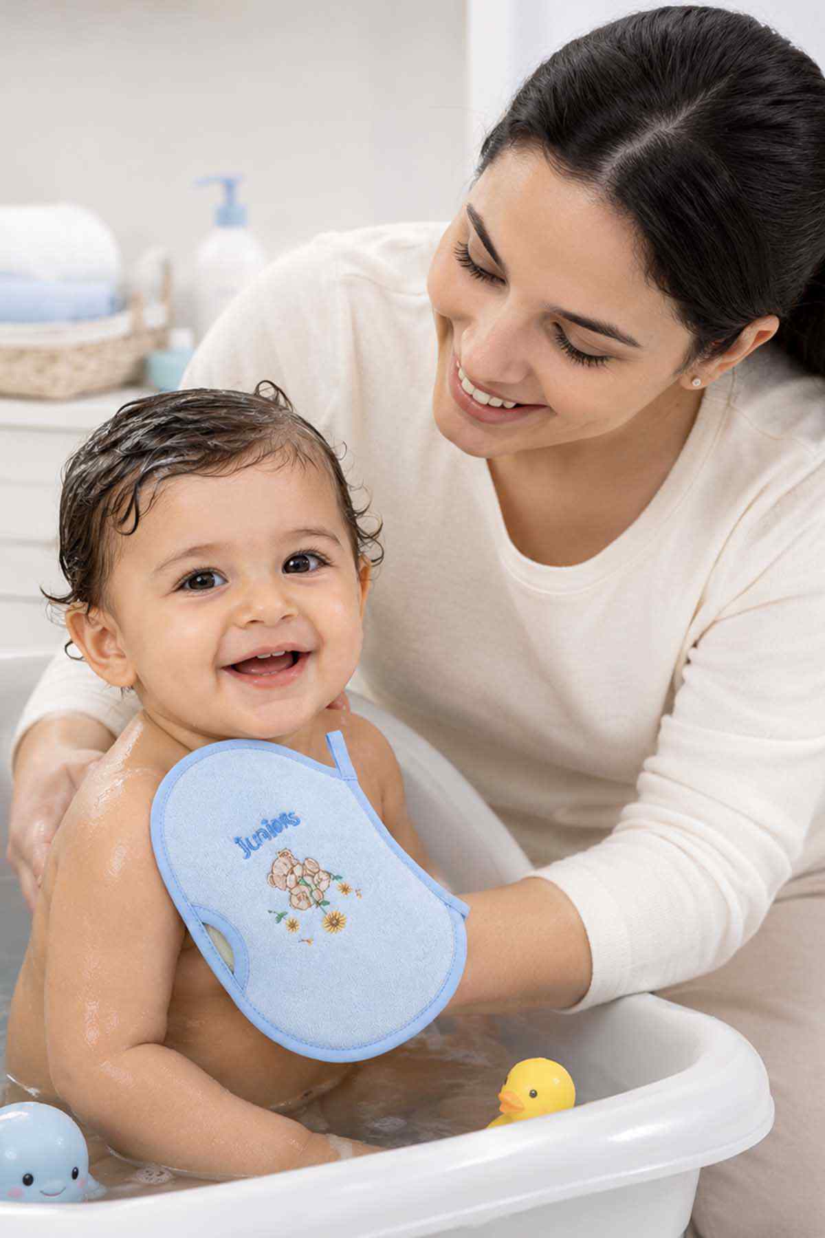 Blue baby bath wash mitt held on a baby, with bear graphic and handle