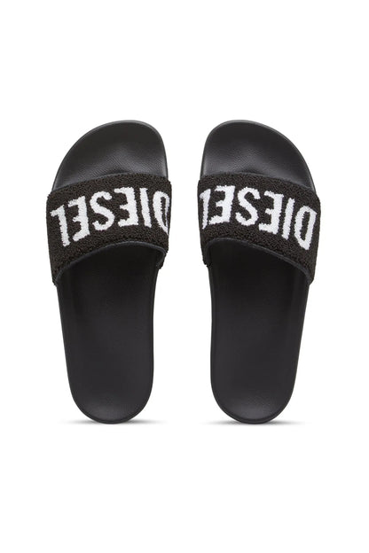 Black slide sandals, pair view showing fuzzy straps with white DIESEL logo