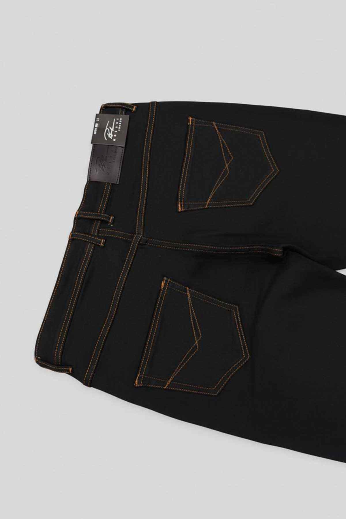 Jet black jeans close-up of front pockets, orange stitching, and brand patch