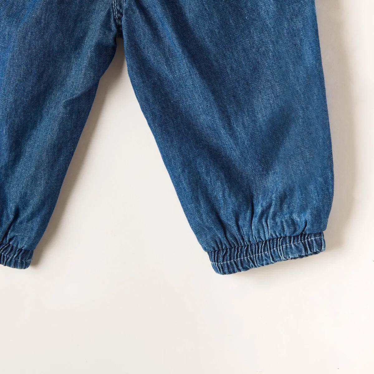 Blue denim baby pants with elastic cuffs and relaxed tapered legs