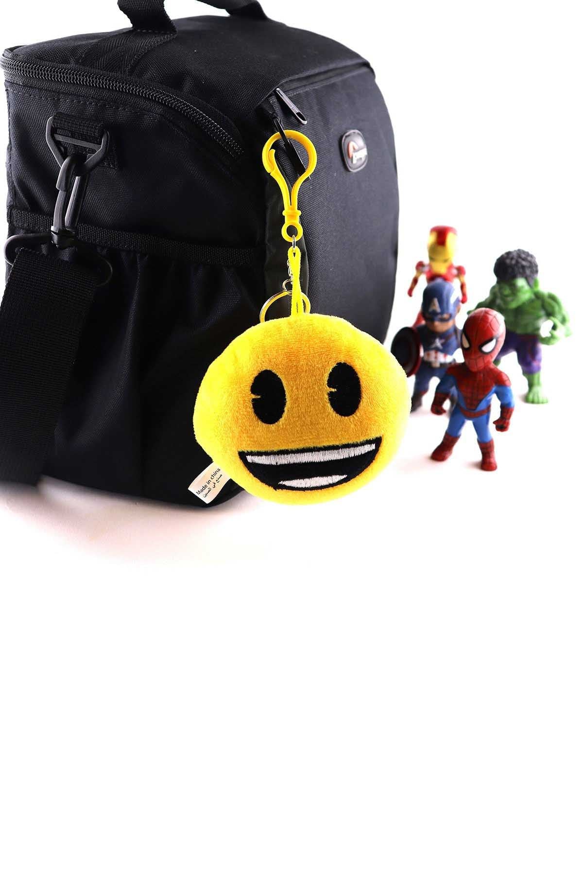 Smiley plush keychain with yellow loop attached to black backpack