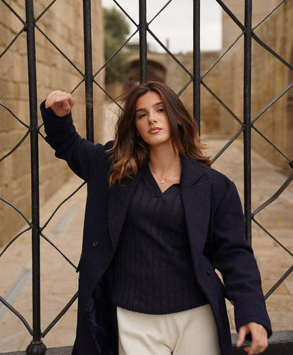 Dark navy fitted knit V-neck sweater under open dark jacket