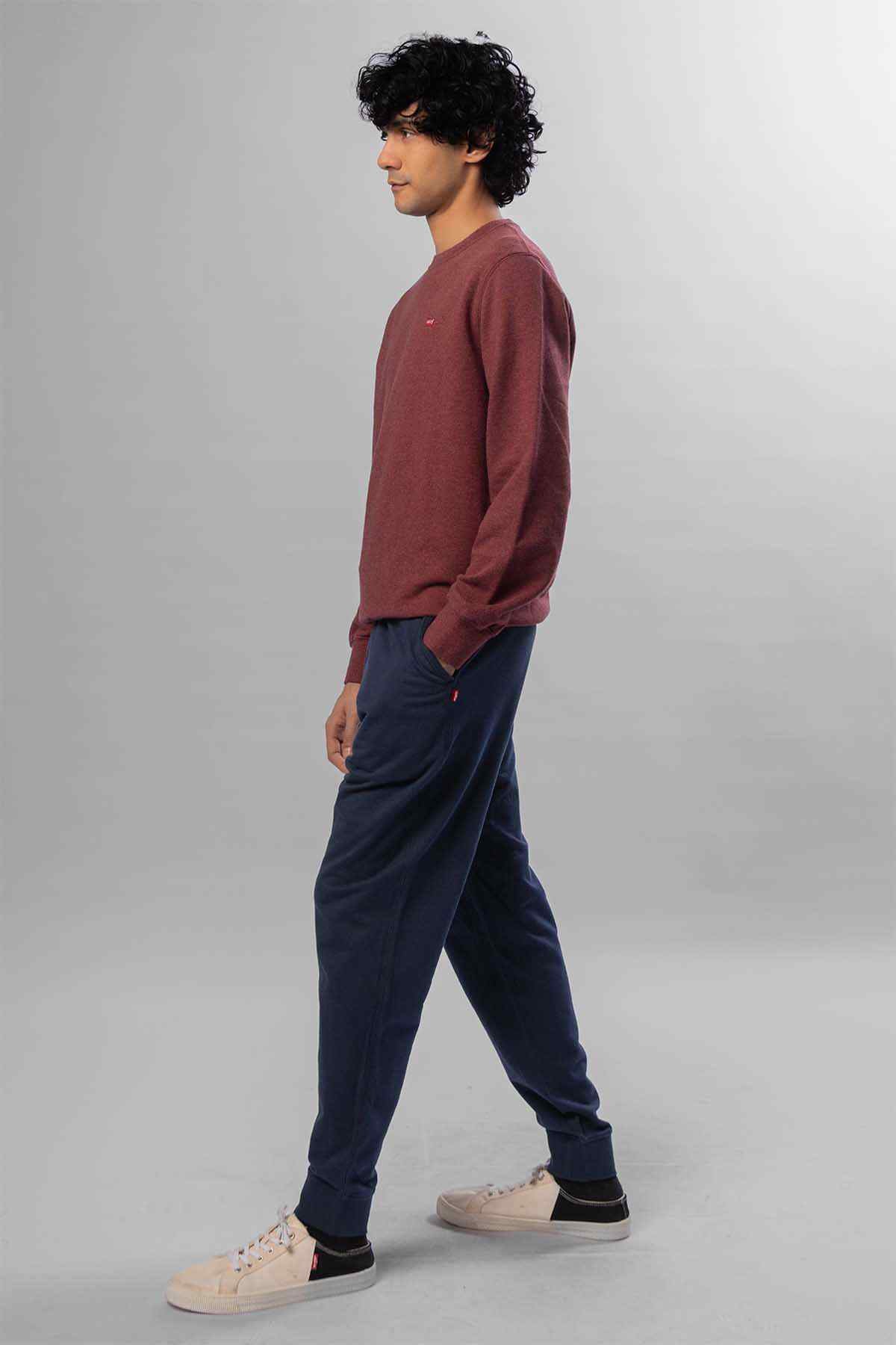 Levi's sweatshirt and dark blue jeans, maroon top with cuffed hem, side view