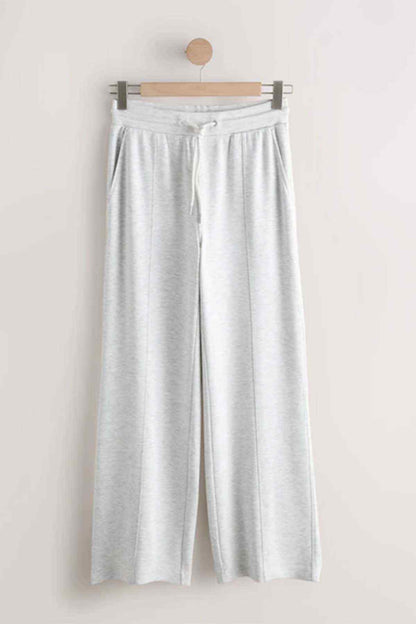 Grey wide-leg jogger trousers on hanger, elastic waist and drawstring front