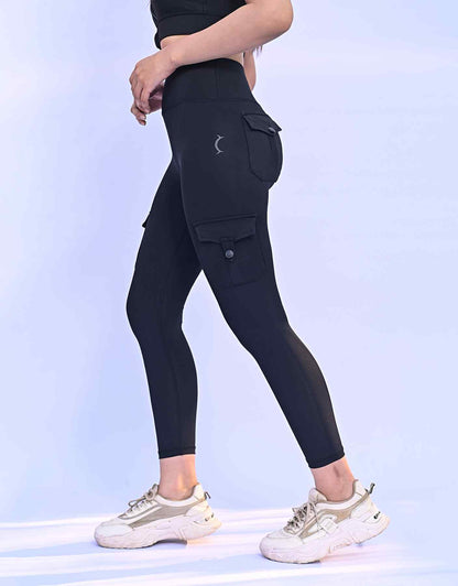 High-rise black cargo leggings with buttoned side pockets and slim ankle fit.