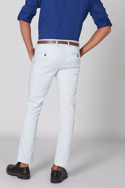 Men's blue shirt hem and light trousers with belt, cropped lower-body view