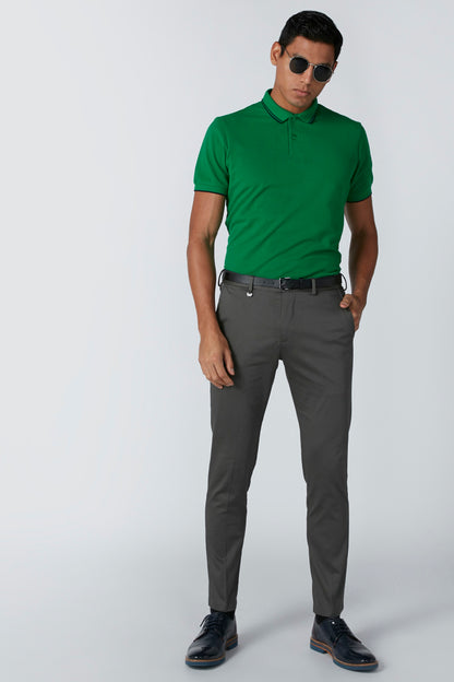 Men's green polo shirt and gray trousers with black belt and sunglasses