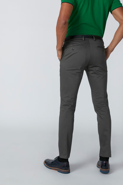 Men's green polo shirt with gray trousers, belt, and dark sneakers