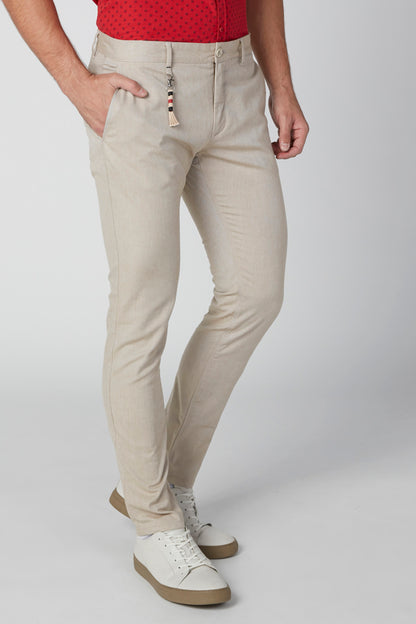 Beige men's slim-fit pants with tapered legs and stitched seams, side view