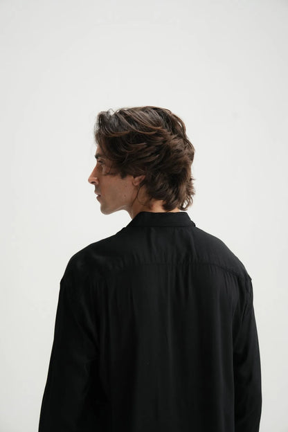Black button-up shirt back view, yoke and long sleeves visible.