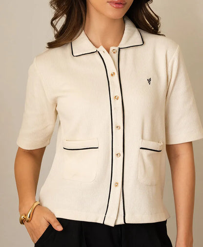 Ivory short-sleeve button-up top close-up: stand collar, contrast trim, chest pockets.