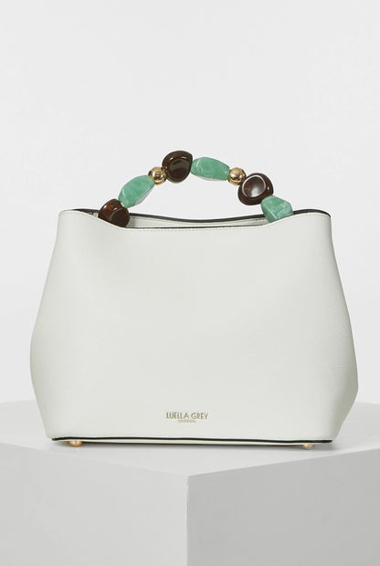 White handbag with beaded top handle in green and brown, gold-tone feet