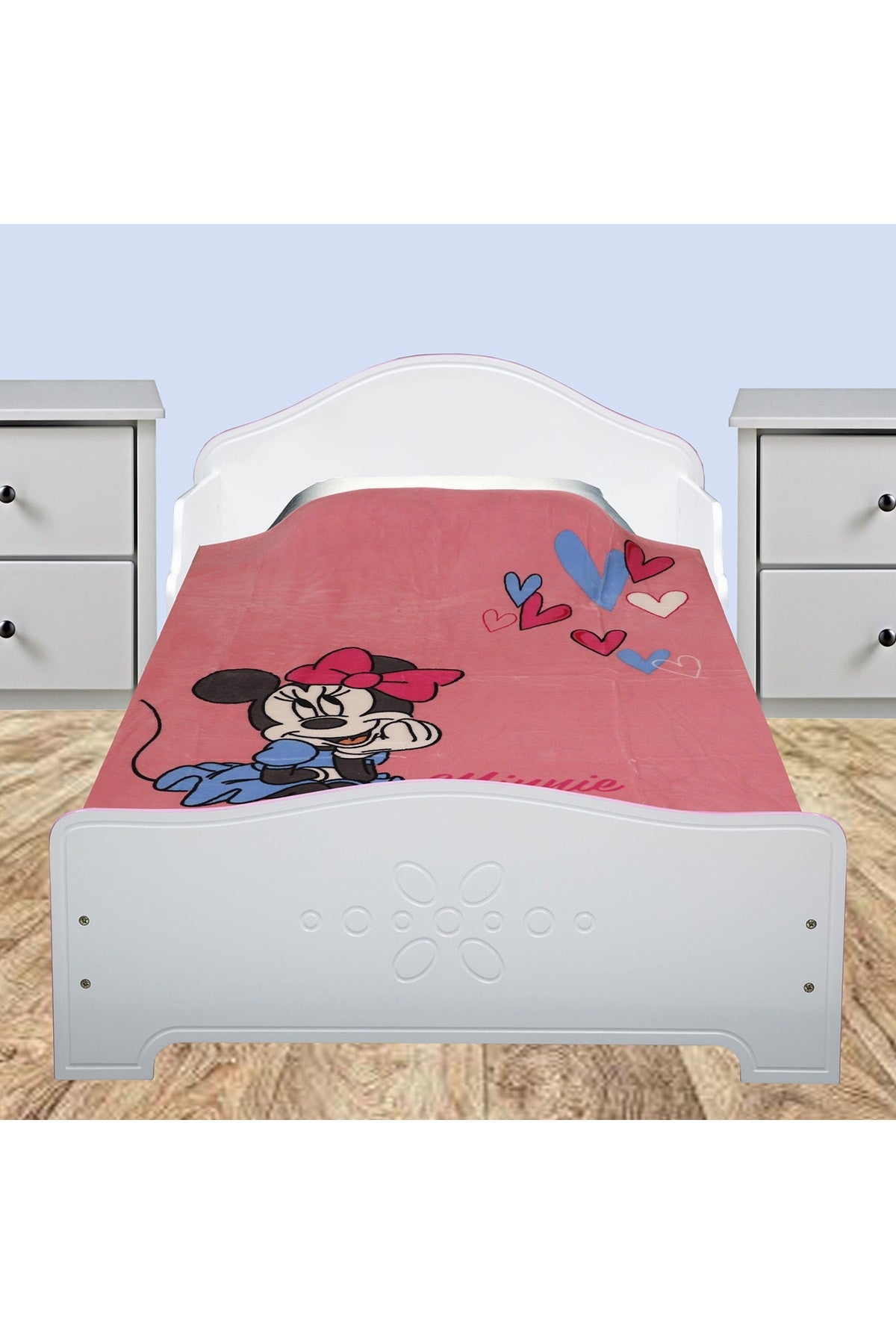 Disney fleece blanket, pink Minnie Mouse design with hearts, laid on bed