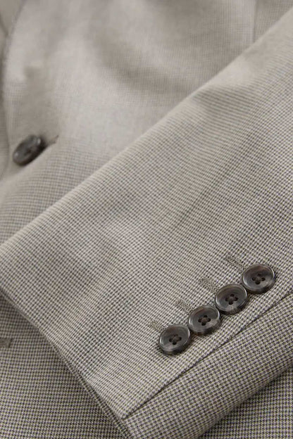 Men's gray blazer cuff with four dark buttons and stitched sleeve hem, close-up.