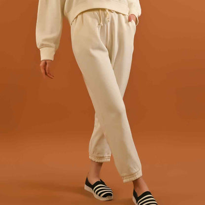 Cream jogger pants with elastic waist and cuffed ankle hems