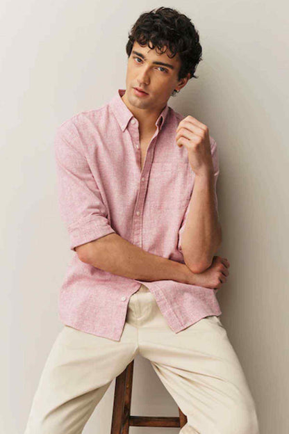 Men's pink button-up shirt with rolled sleeves and open collar tips