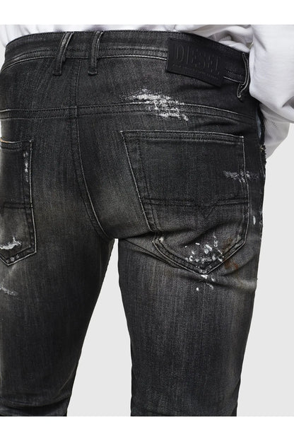 Men’s dark black jeans, back pocket and waistband with distressed paint-like marks