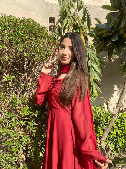 Red long-sleeve maxi dress with ruffled shoulder detail and gathered bodice, outdoors side view