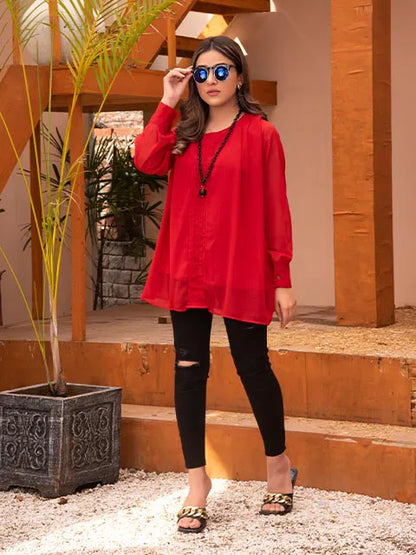 Nazmina red long tunic with round neck and long sleeves, black ripped skinny jeans, front view