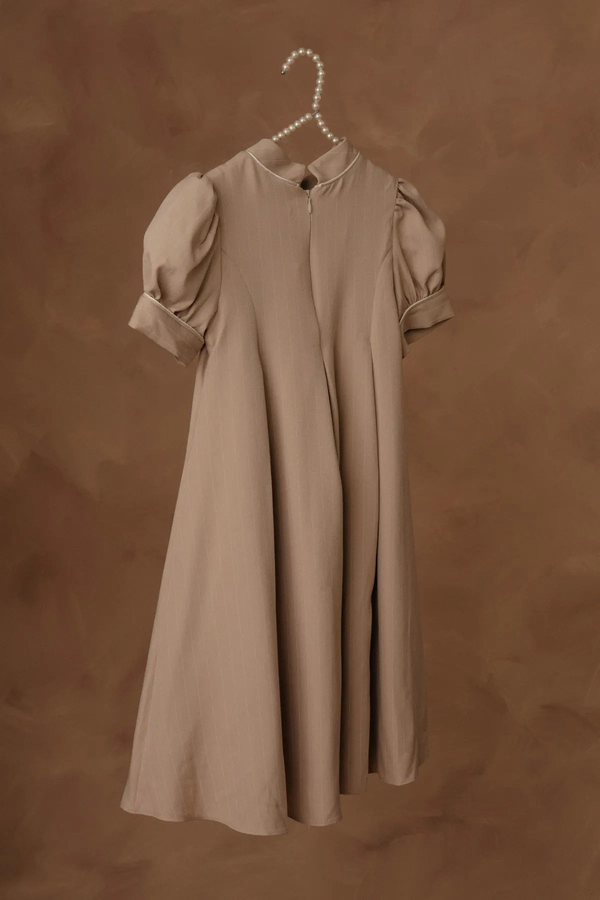 Stone dress on hanger with puff sleeves and gathered, flared skirt