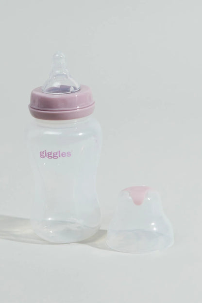Clear baby bottle with pink lid and drinking spout, 'giggles' text; small cap beside it