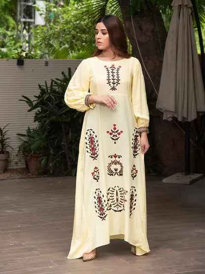 Pale yellow embroidered long dress, side view, round neck and multicolor motif details