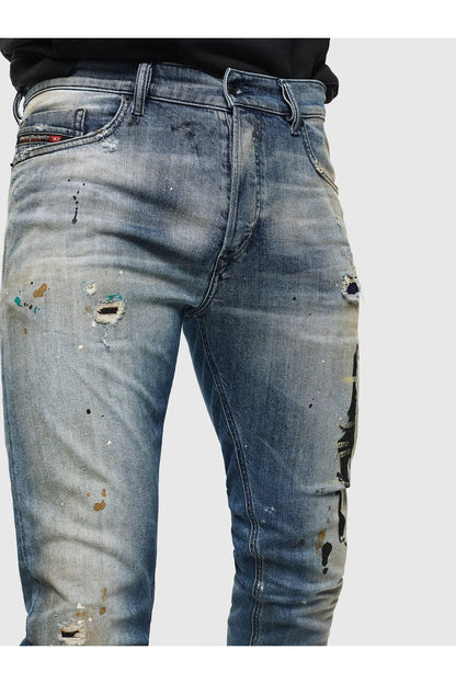 Indigo denim jeans with paint splatter and ripped details at front thighs