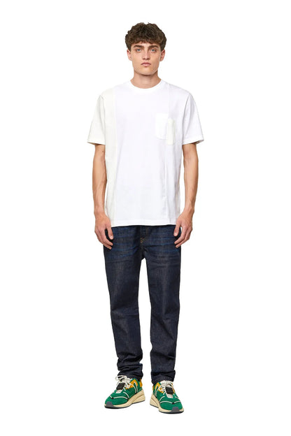 Man wearing green sneakers with jeans and a white T-shirt