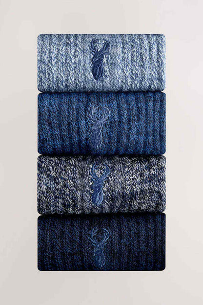 Stack of folded blue knit socks with ribbed cuffs and small logo