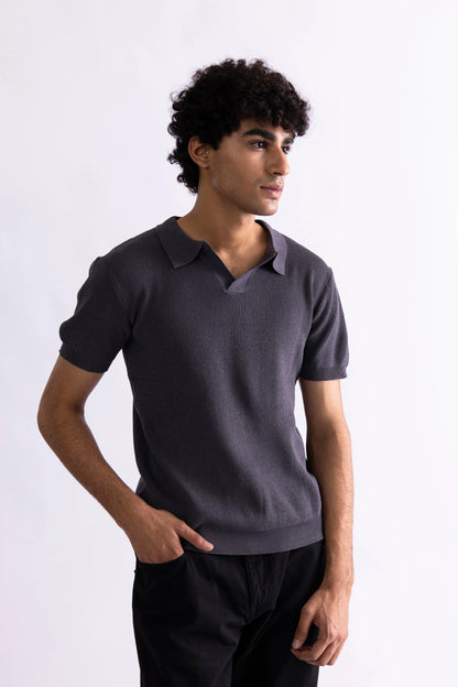 Men's dark gray polo shirt with short sleeves and collar, casual side stance