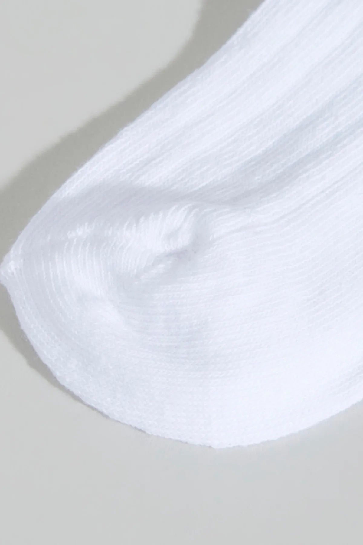 White baby ankle sock close-up, ribbed knit with soft fabric texture