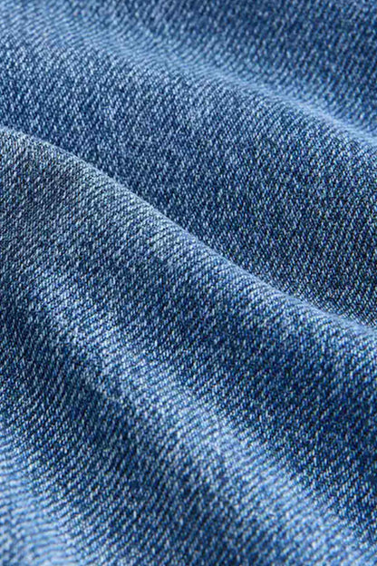Blue denim fabric close-up showing woven texture