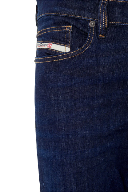 Blue denim jeans close-up of front pocket with orange stitch and label patch