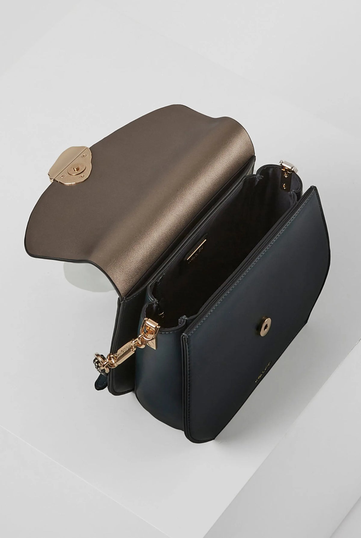 Black flap crossbody bag with gold hardware, chain strap, and zip pocket