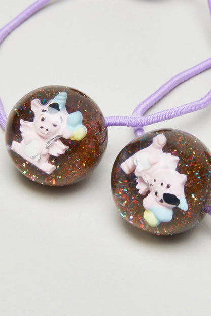 Pair of glittery brown bead charms with cartoon baby animal on purple elastic