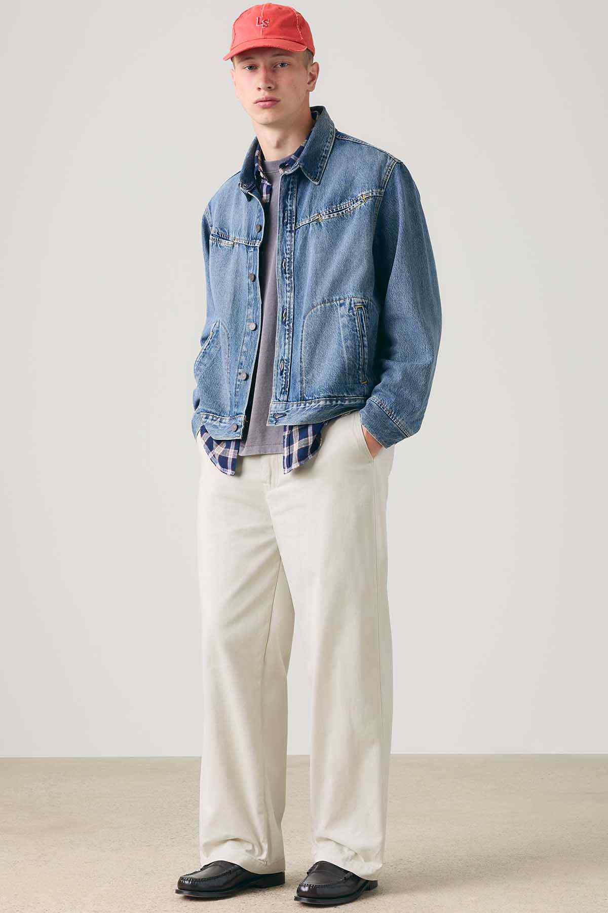 Levi's blue denim jacket over beige pants and red cap