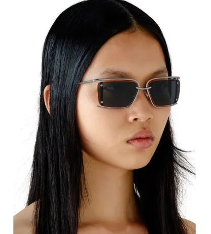 Diesel sunglasses on model, dark lenses, silver frame with orange accents