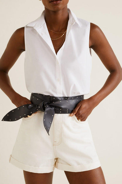 Off-white sleeveless button-up shirt and matching shorts with black dotted belt
