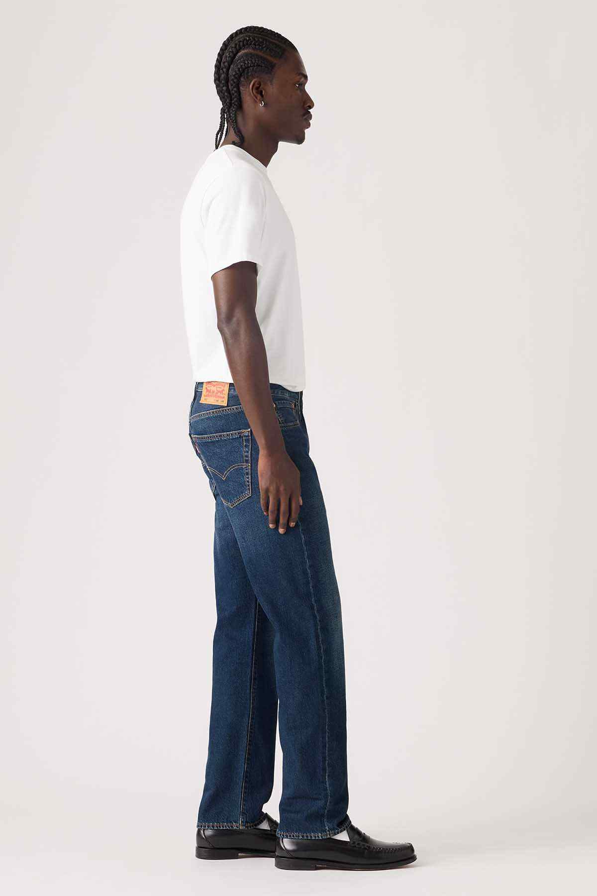 Dark wash denim jeans side view, straight leg with stitched back yoke